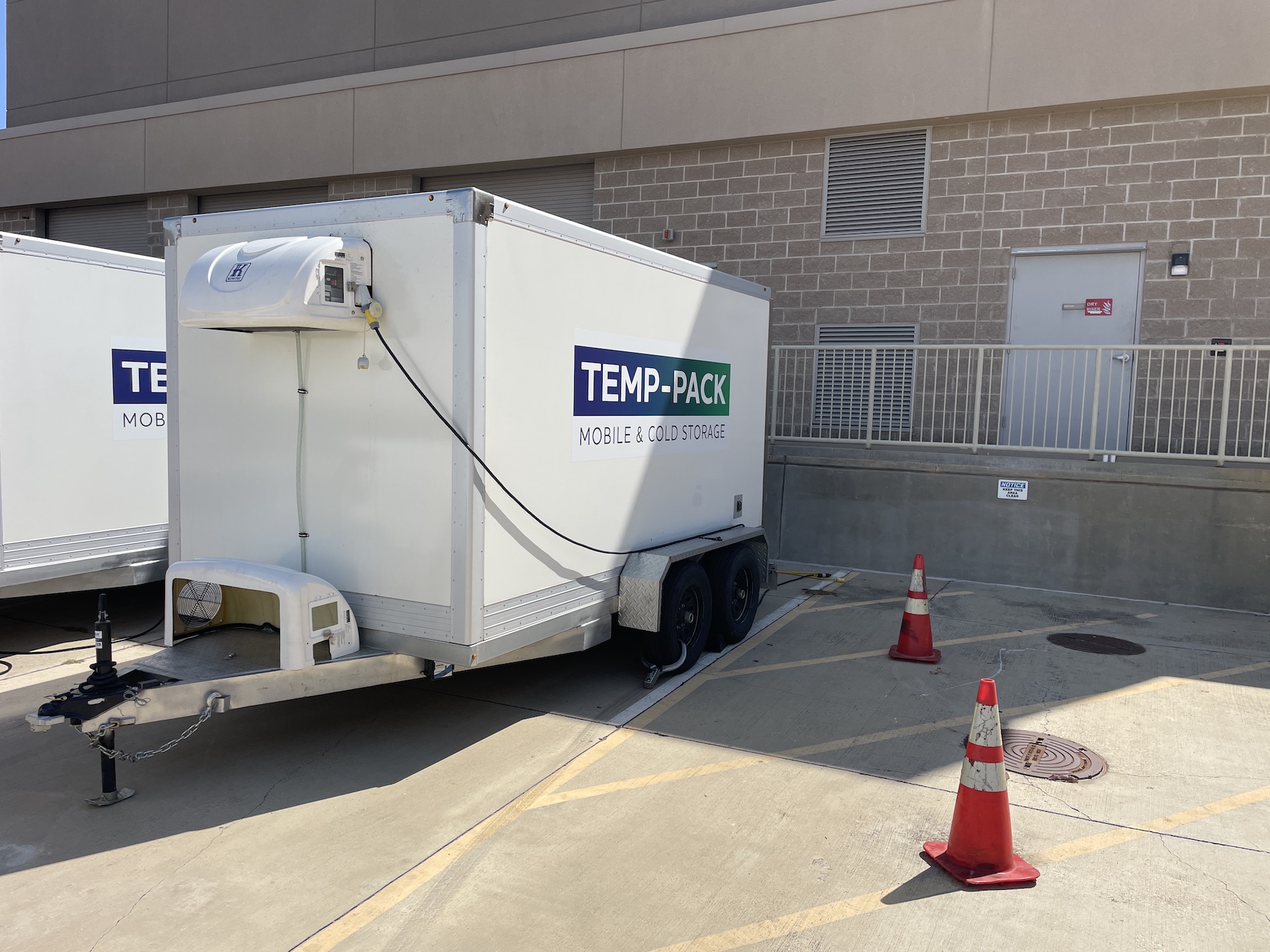 TEMP-PACK refrigerated trailer beside a commercial building