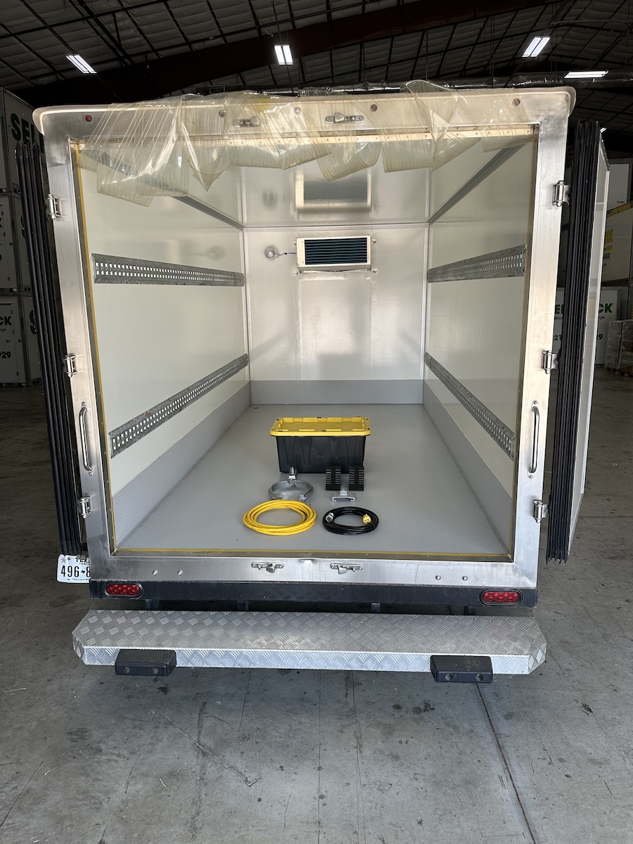 Interior of a refrigerated trailer with tie rails and delivery equipment
